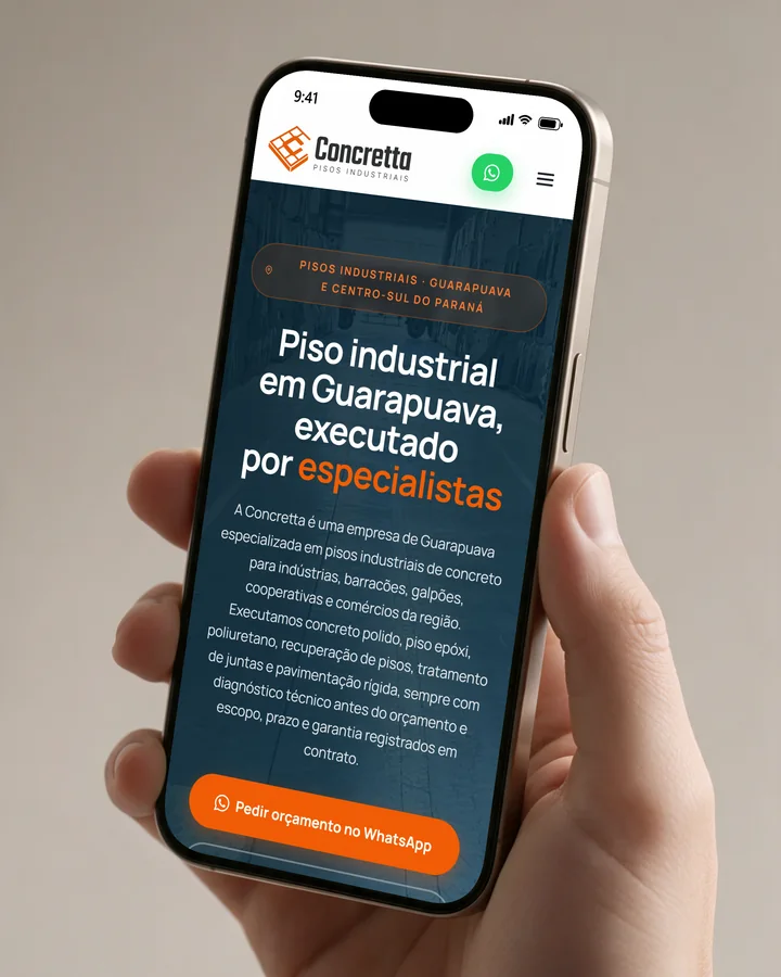 Mão segurando um celular com o site Concretta Pisos aberto