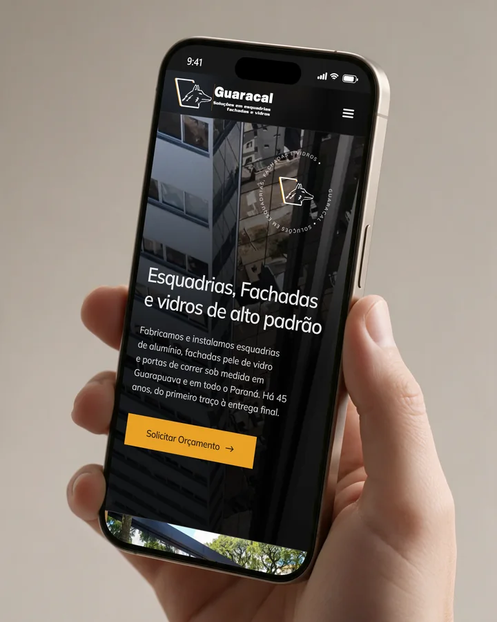 Mão segurando um celular com o site Guaracal aberto