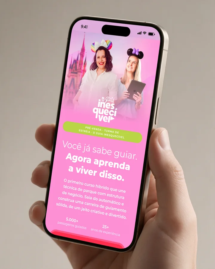 Mão segurando um celular com o site O Guia Inesquecível aberto